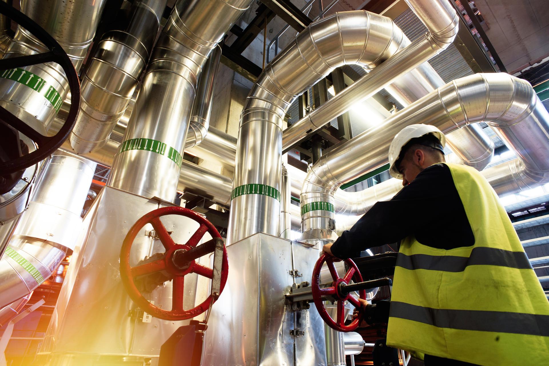 factory worker turning valve