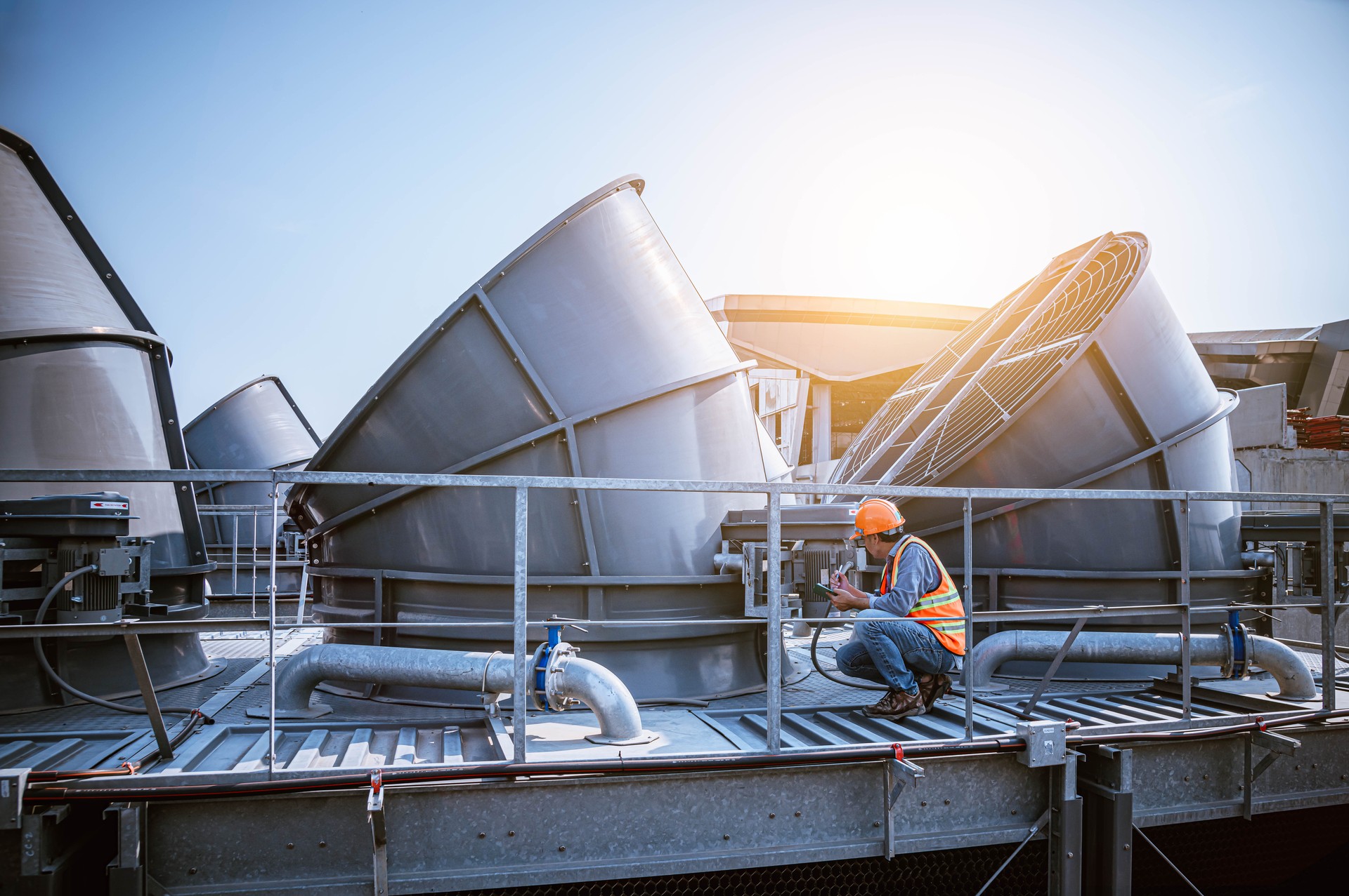 engineer under checking the industry cooling tower air conditioner is water cooling tower air chiller HVAC of large industrial building to control air system.