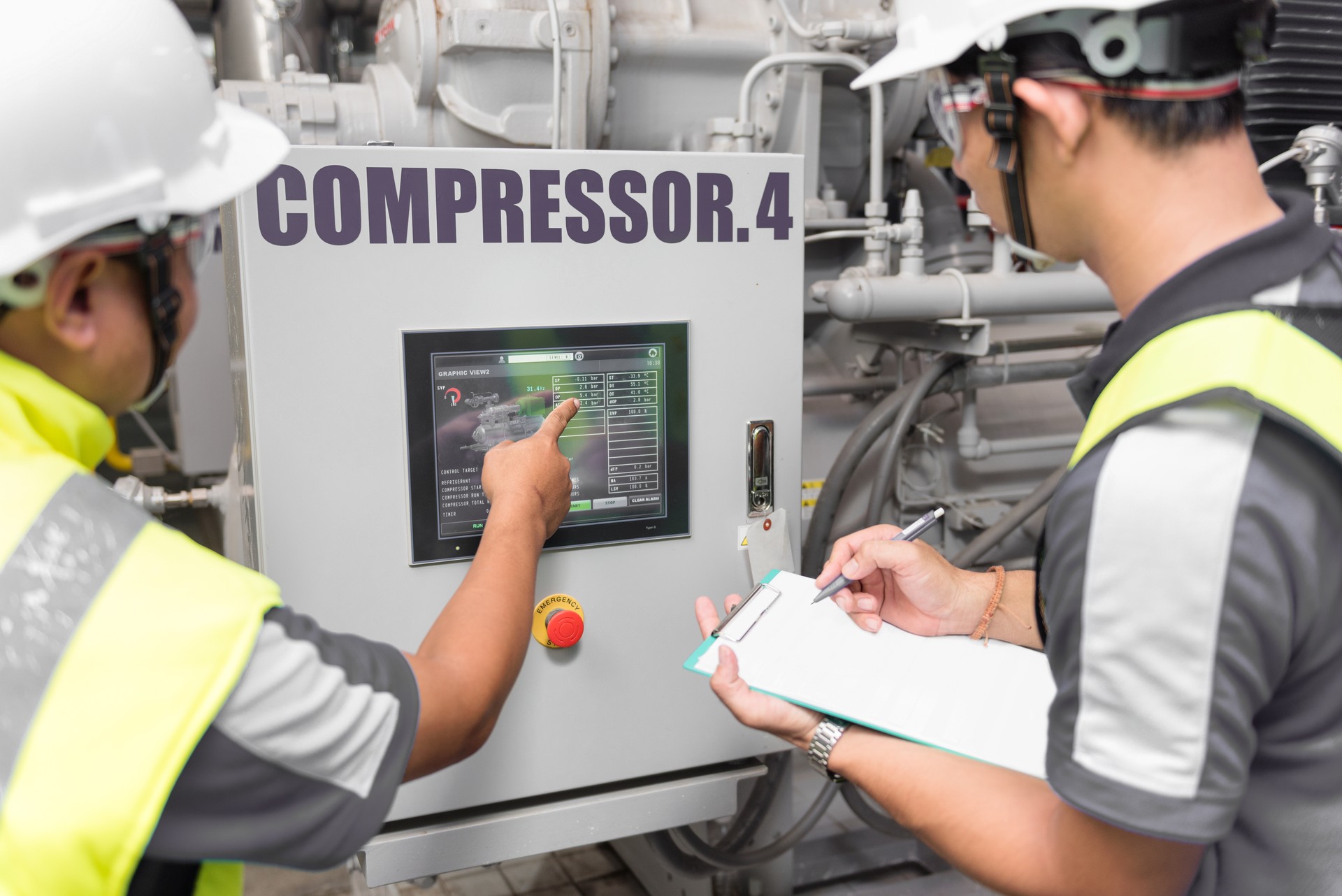 Engineers control in machine room and looking to monitor of compressor