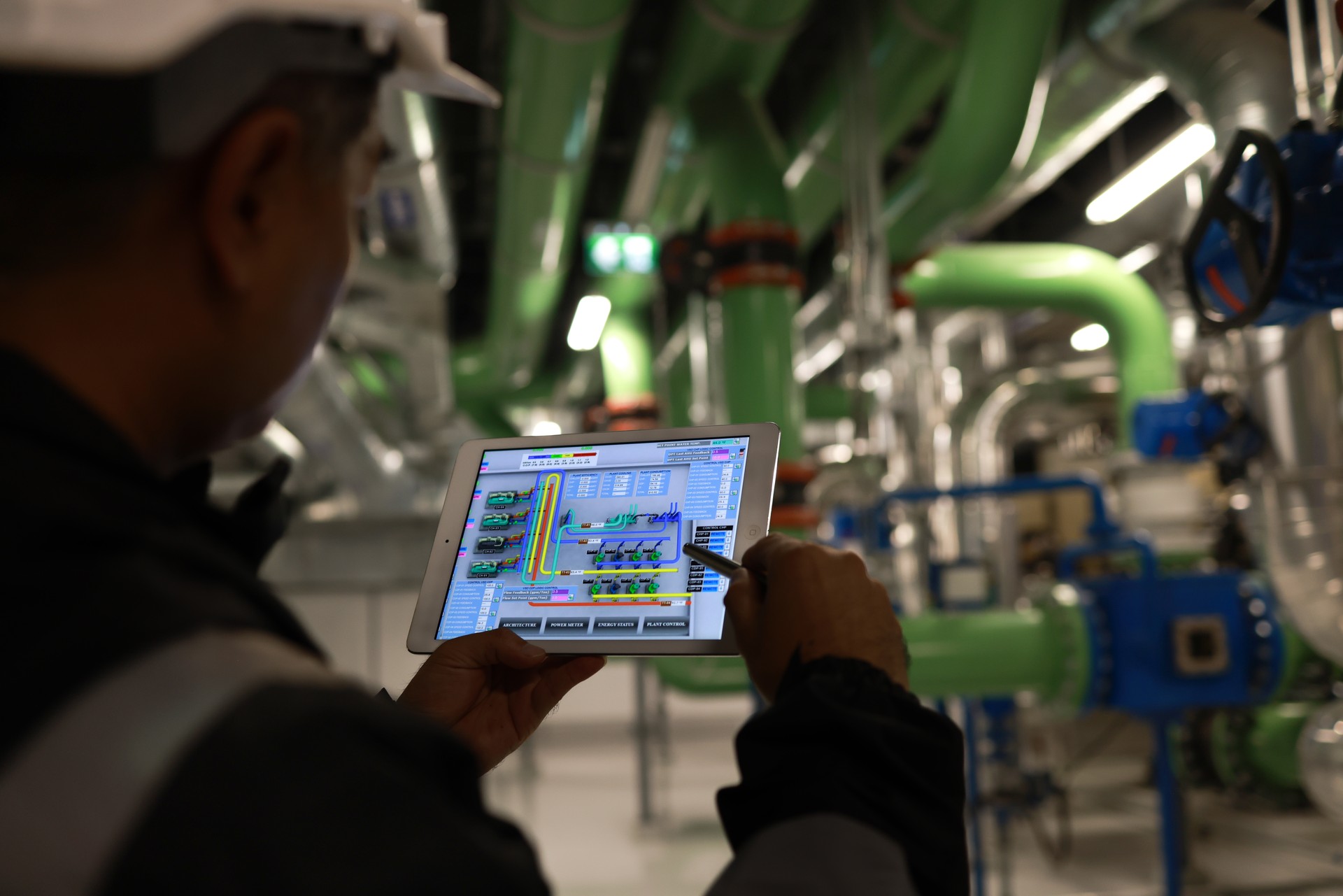 Mechanical Engineer using a digital tablet to Examine the Pipeline  system of cooling installation